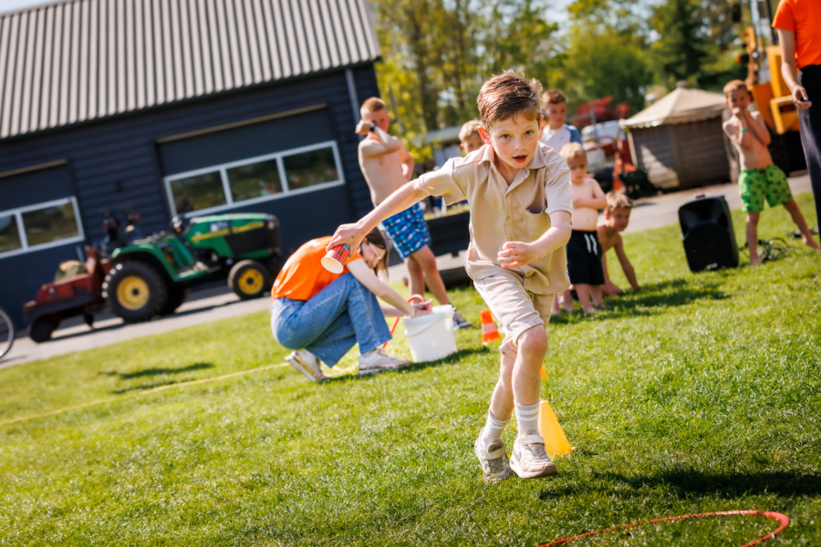 Kind dat waterestaffete doet tijdens de animatie van Vakantiepark de Luttenberg