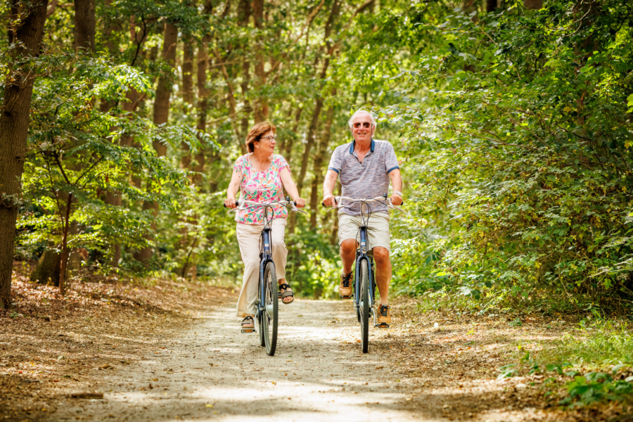 Ouderen fietsend door naastgelegen bos Vakantiepark de Luttenberg