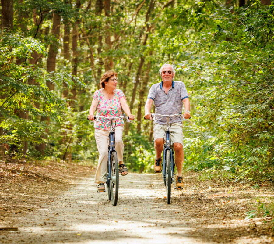 Ouderen fietsend door naastgelegen bos Vakantiepark de Luttenberg