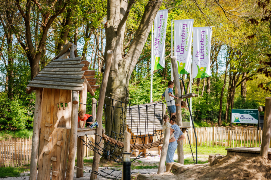 Gezin speelt in het speeltoestel bij de ingang van de Luttenberg