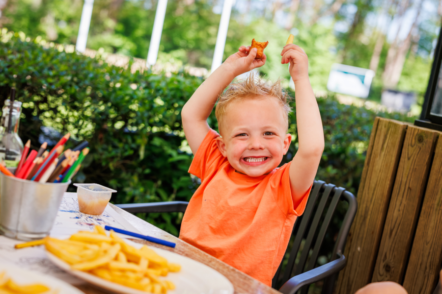Kind is blij met het eten en zijn kleurplaat in de horeca bij de Luttenberg