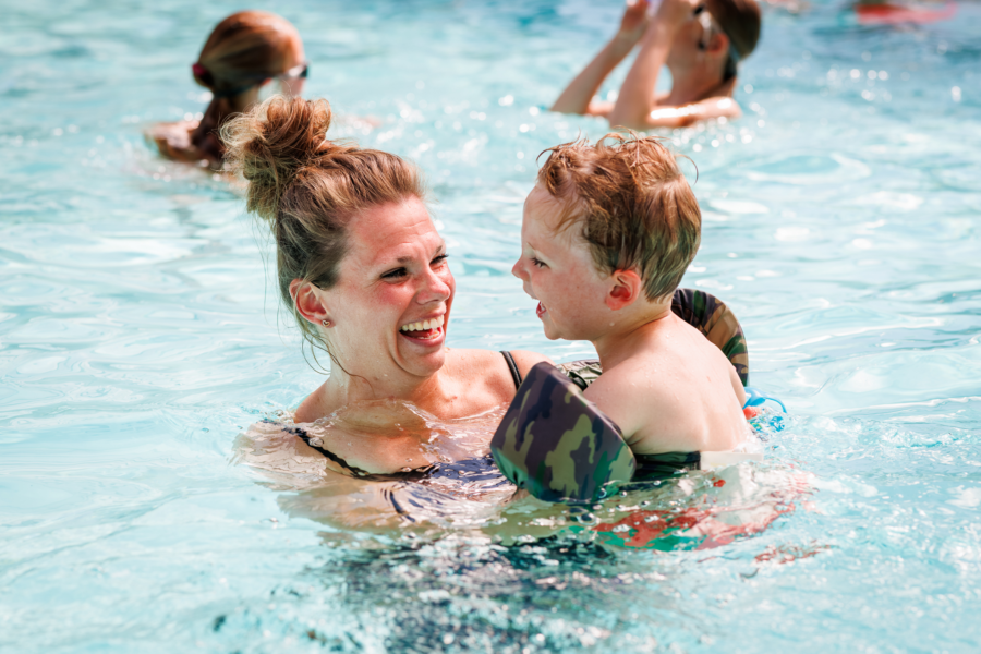 Moeder en zoon die samen zwemmen op de camping