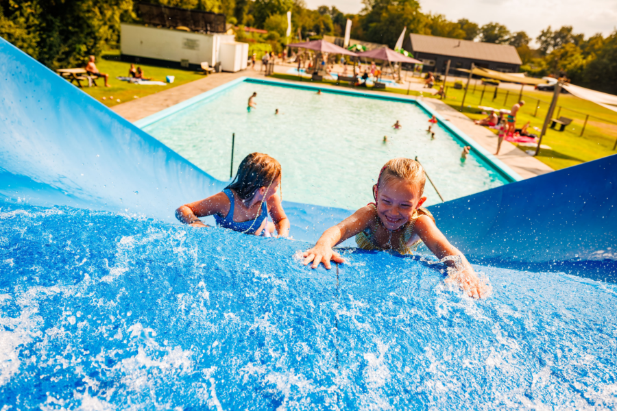 Kinderen die van de waterglijbaan afgaan buiten