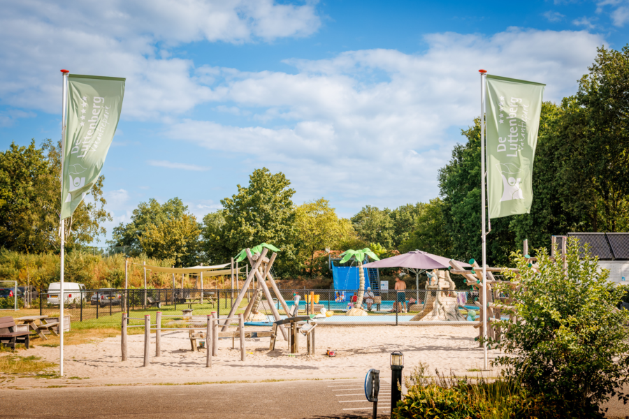 Grote speeltuin vooraan vakantiepark de luttenberg met buitenzwembad en spraypark erachter